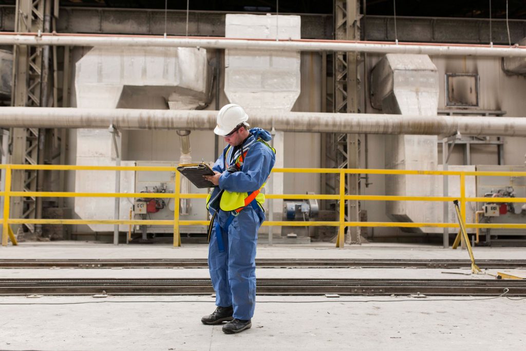 man taking notes on a clipboard from outside a building site